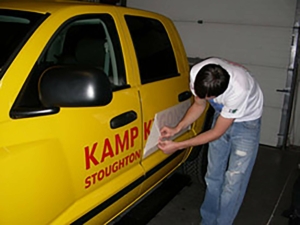 Person installing vehicle lettering